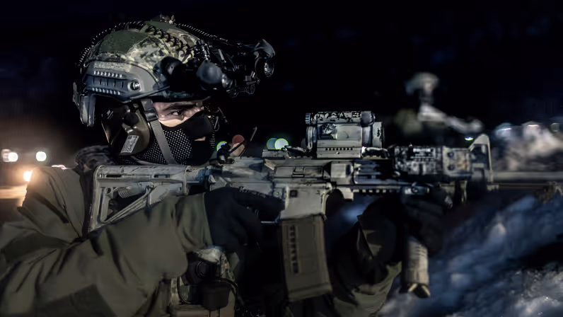 Marinier met helm en gezichtsmasker richt zijn wapen.