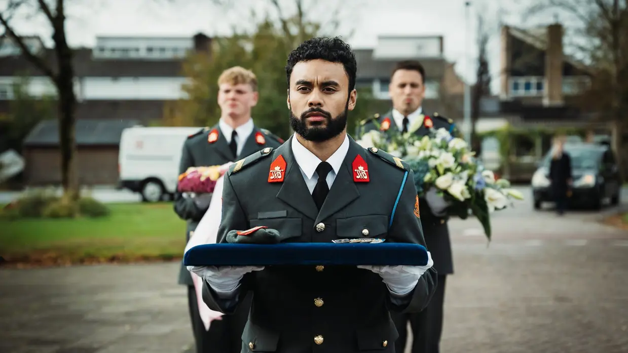  Mix van beelden van Mark. Zo zien we dat zijn kist wordt gedragen door militairen en dat zijn baret en onderscheidingen plechtig worden gedragen door een collega.