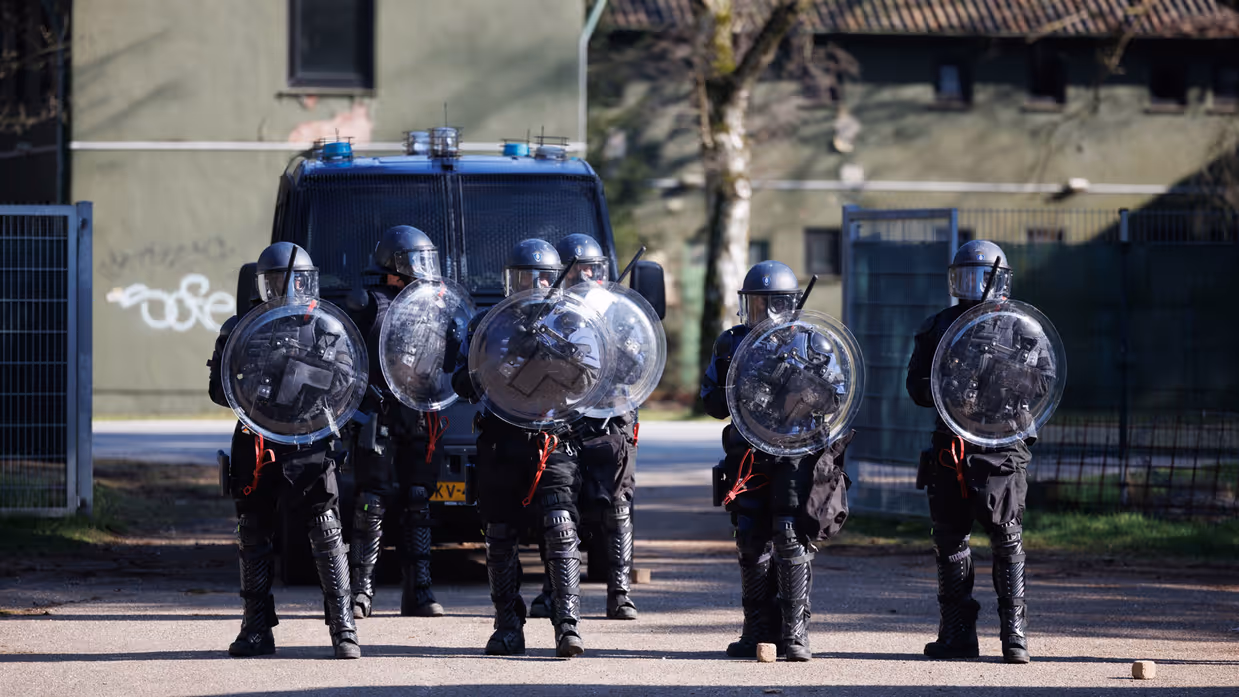 Marechaussees van de ME op linie met schilden.