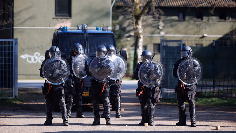 Marechaussees van de ME op linie met schilden.