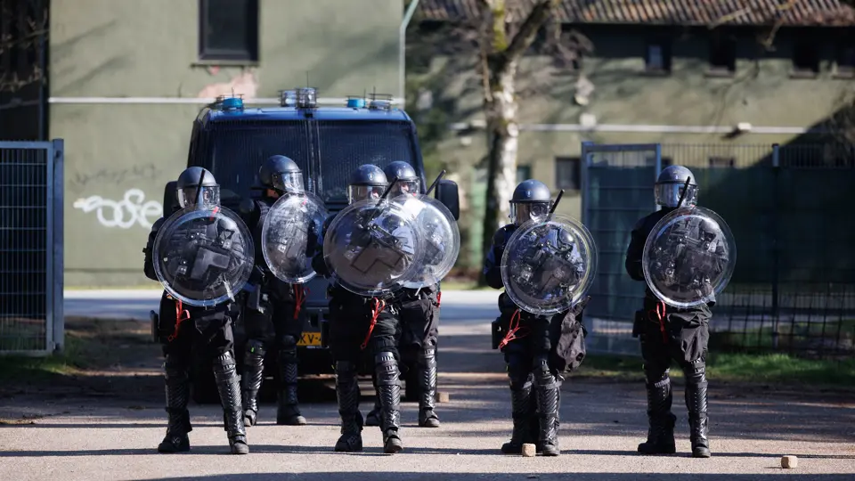 Marechaussees van de ME op linie met schilden.