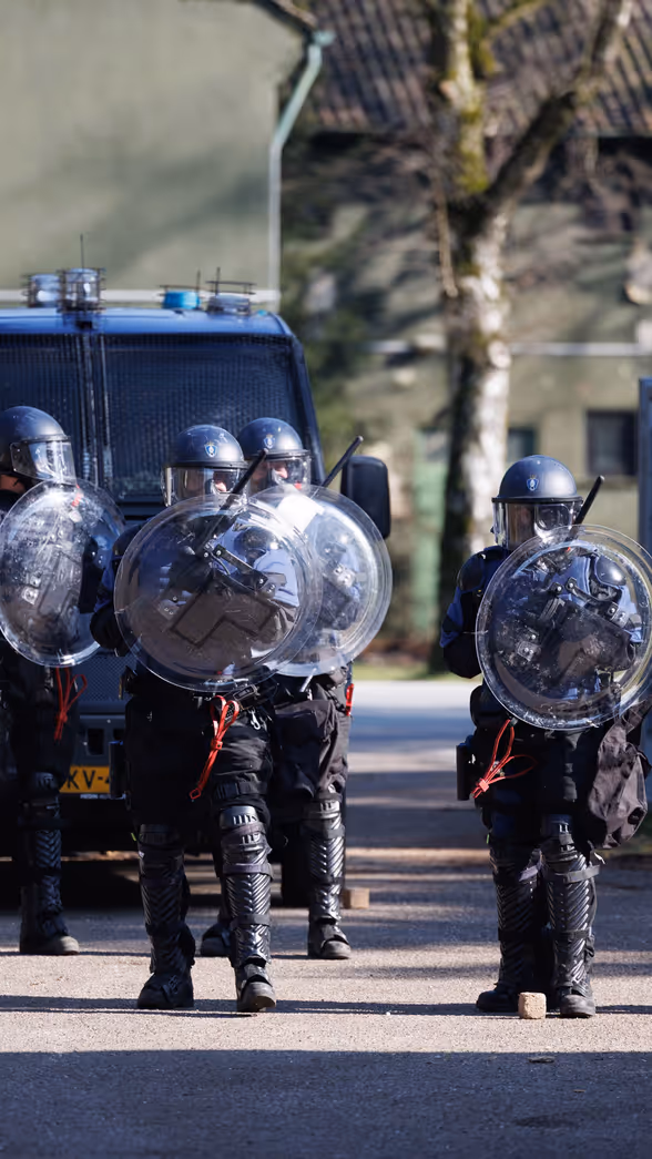 Marechaussees van de ME op linie met schilden.