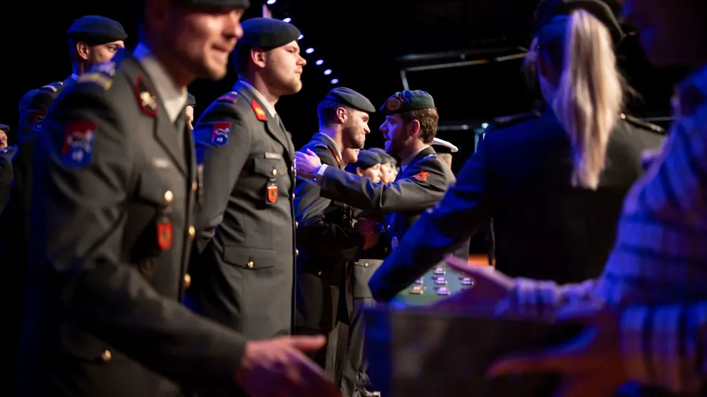 Militairen staan in tenue in rij te wachten op hun medaille