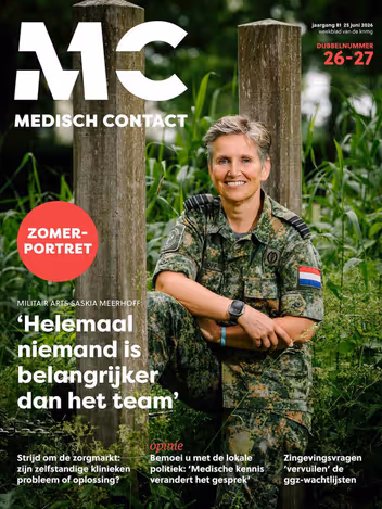 De cover van Medisch Contact toont een glimlachende militair arts in camouflagekleding, zittend tussen groene planten en houten palen.