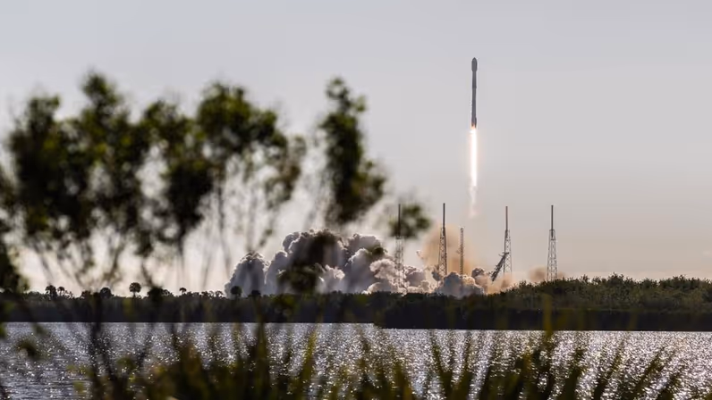 Een raket stijgt met veel rook en vuur op vanaf een lanceerplatform. 