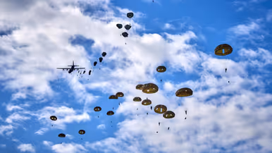parachutisten zijn uit een vliegtuig gesprongen en zweven naar beneden aan hun parachutes.