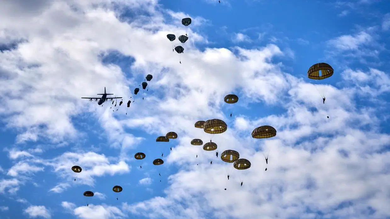 parachutisten zijn uit een vliegtuig gesprongen en zweven naar beneden aan hun parachutes.