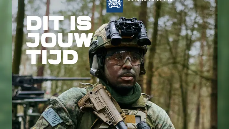 Een man in militaire kleding kijkt langs de camera.
