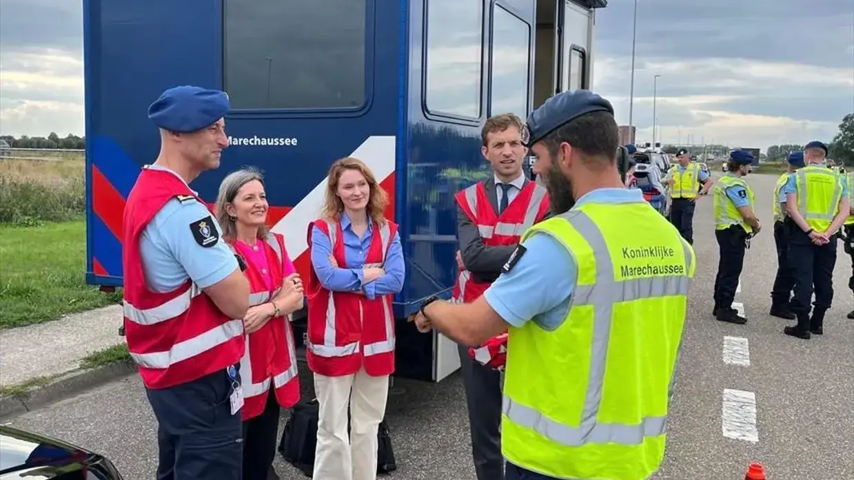 Marechaussees aan de grens geven uitleg aan de directeur-generaal.