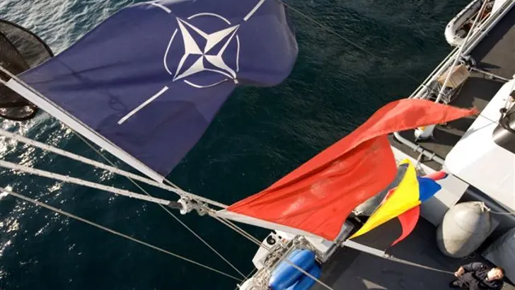 De mast van een mijnenjager vanaf boven gezien met de NAVO-vlag.