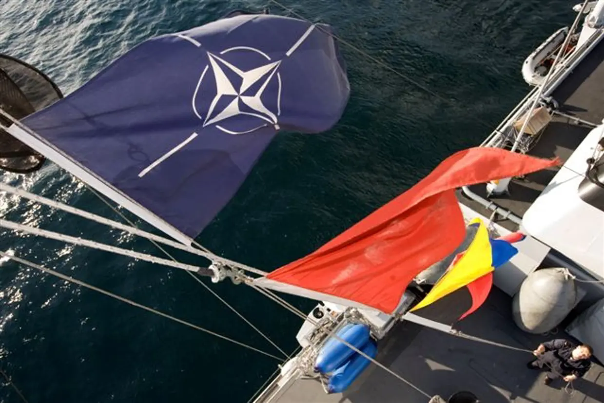 De mast van een mijnenjager vanaf boven gezien met de NAVO-vlag.