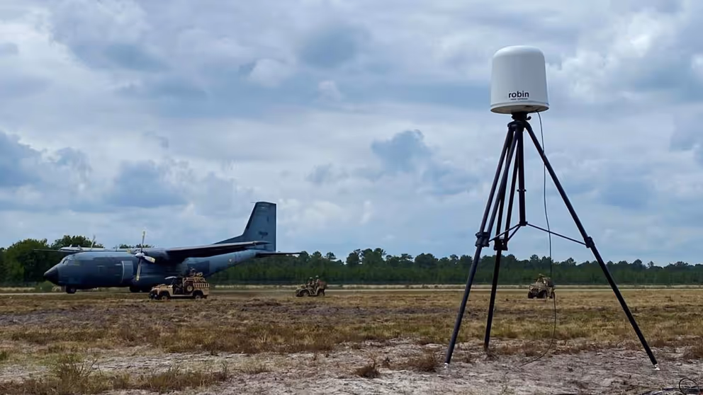 Een vliegtuig op de grond, met daarvoor een antidrone systeem.