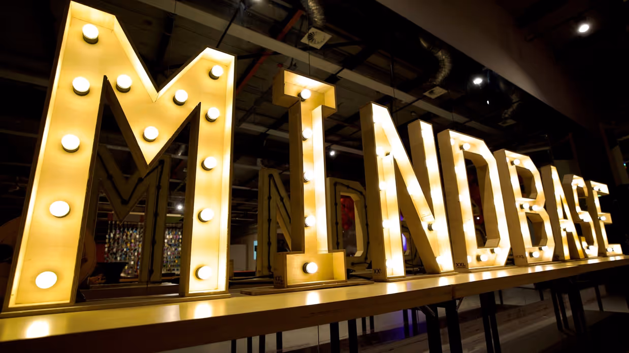 Gele, oplichtende letters die het woord ‘Mindbase’ vormen.
