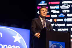 Minister Brekelmans staat achter een katheder.