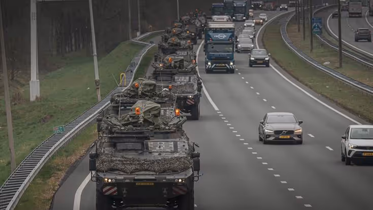 Militaire colonne rijdt over snelweg.