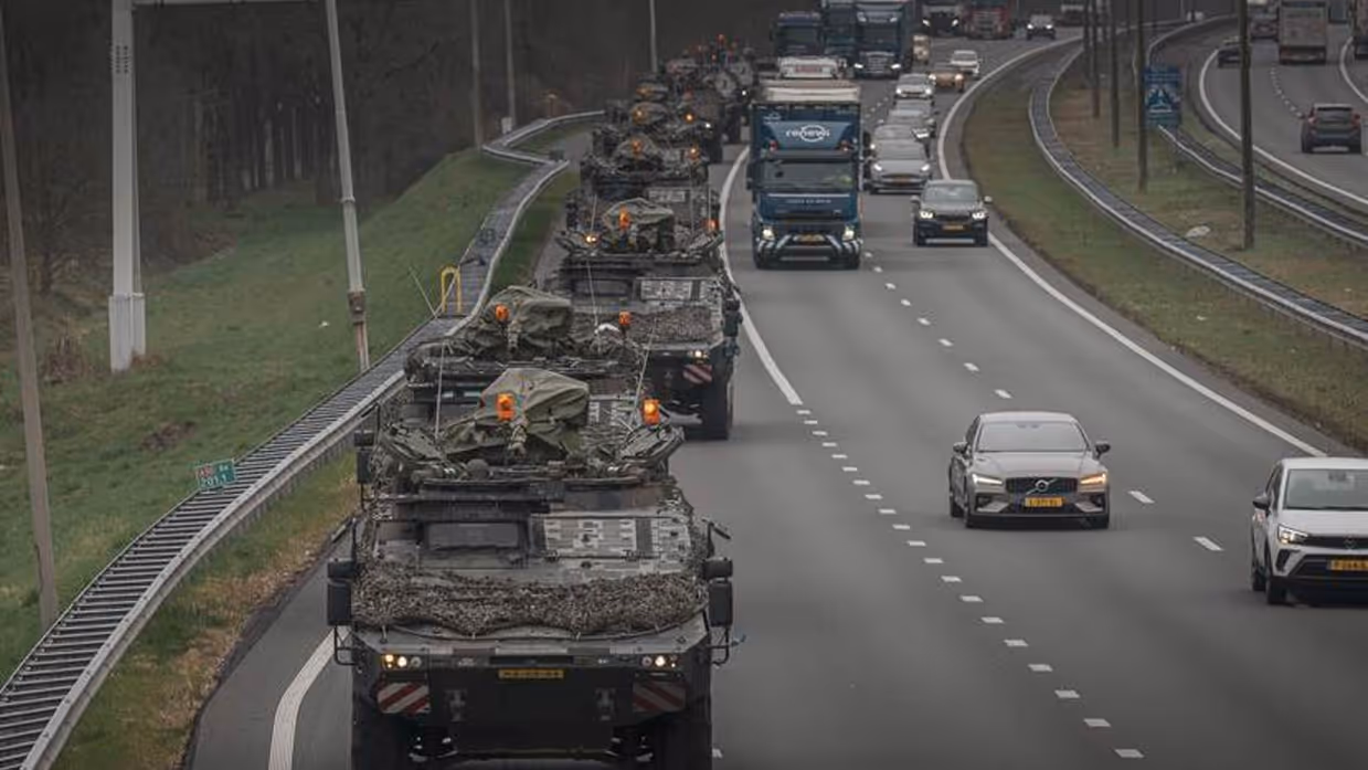 Militaire colonne rijdt over snelweg.