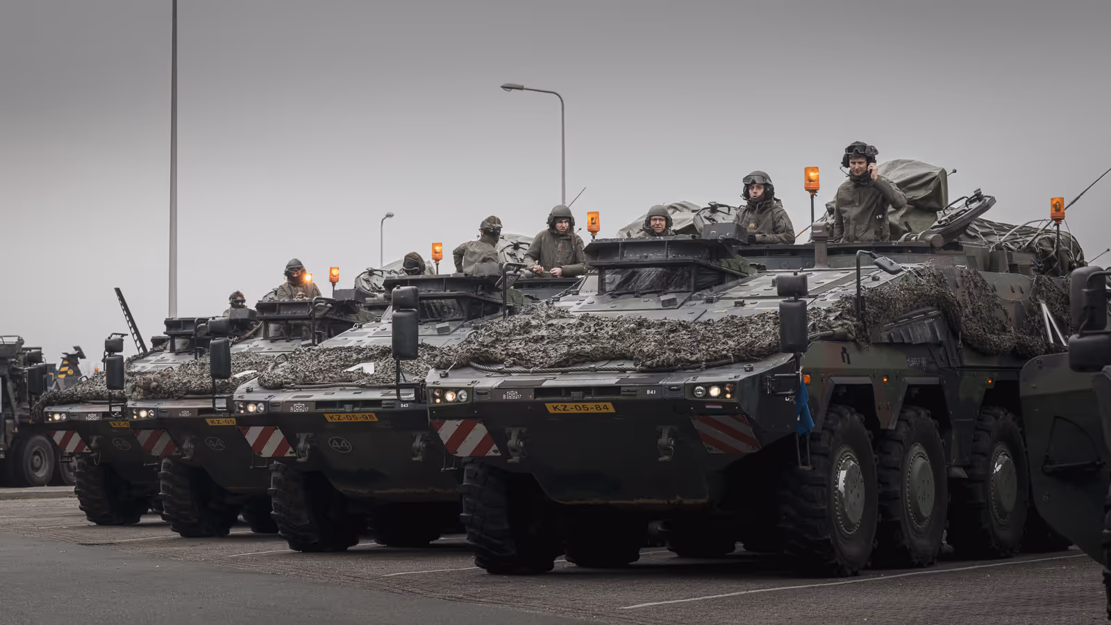 Boxer-pantservoertuigen op rij met militairen erin.