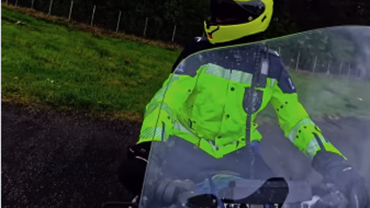 Een motorrijder van de KMar op de snelweg van voren gezien.