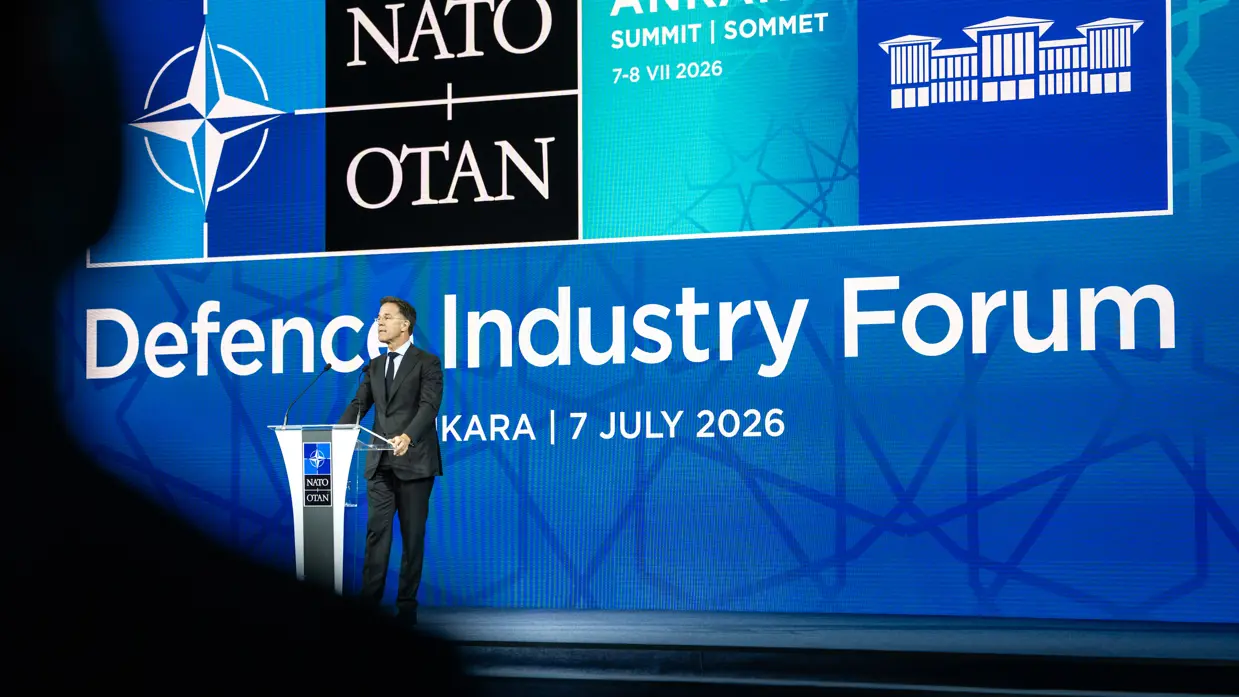 Mark Rutte achter een microfoon. Op de achtergrond een blauwe wand met de tekst ‘Defence Industry Forum’.