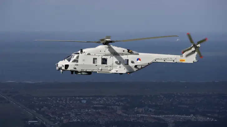 NH90 helikopter boven kustgebied.
