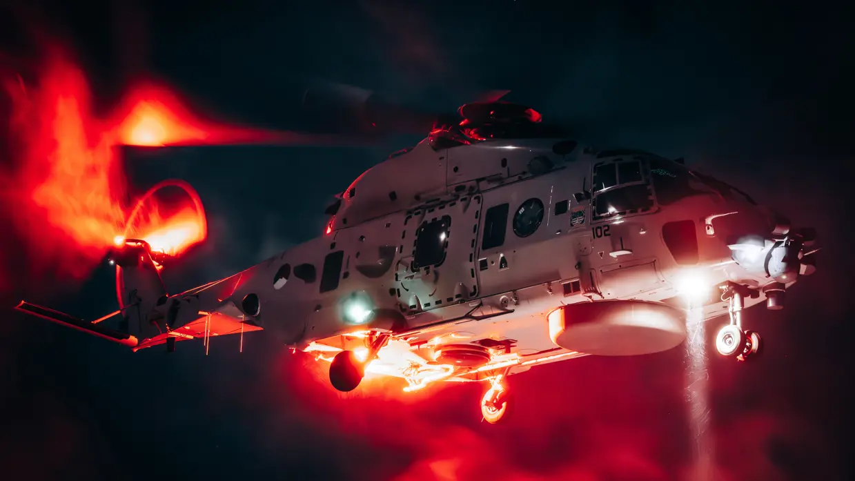 Een NH90 boordhelikopter stijgt op bij nacht.