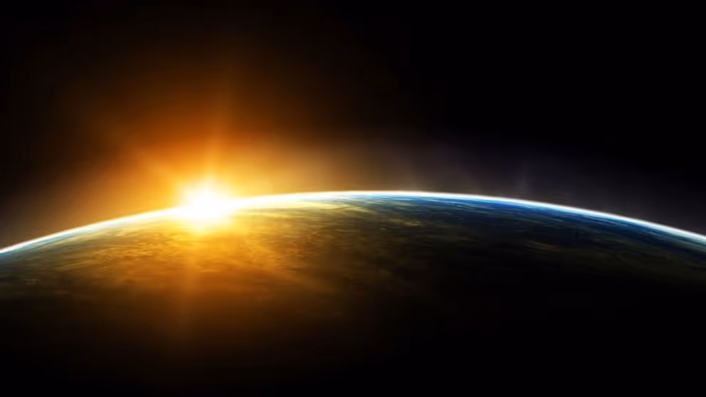 Ruimtefoto van bolling van de aarde met opkomende zon die over deel aarde schijnt.