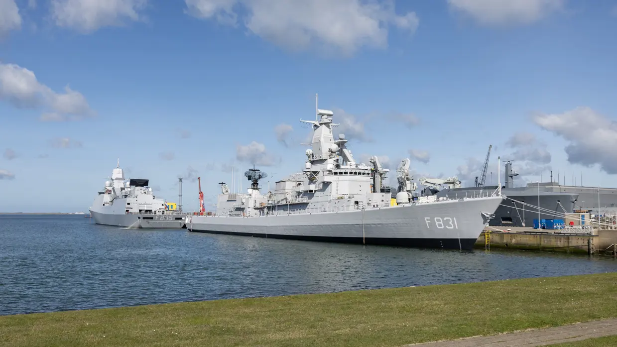 Twee fregatten liggen tegen de kade in de marinehaven.
