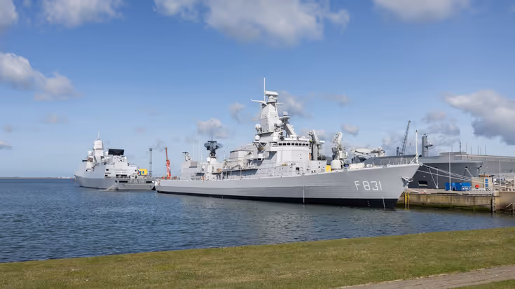 Twee fregatten liggen tegen de kade in de marinehaven.