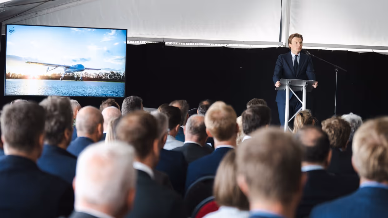 De minister speecht tijdens een evenement.