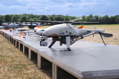Tentoongestelde drones op platform in open veld.