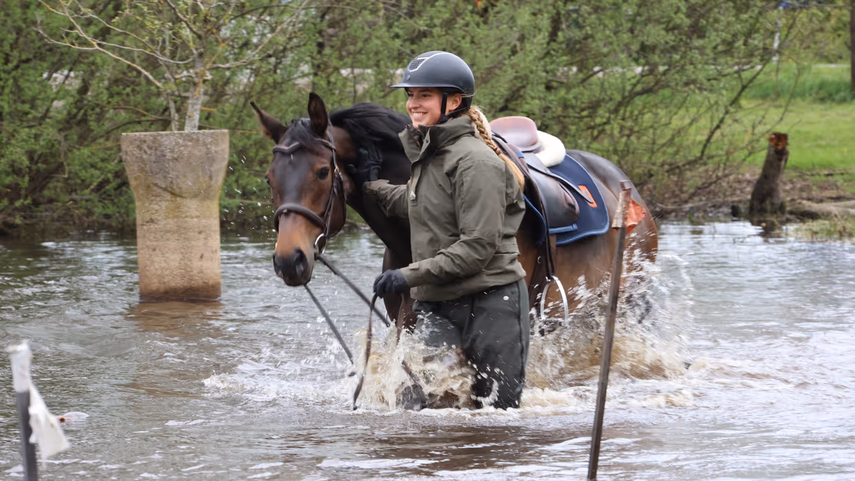 Een glimlachende vrouw met een helm op leidt met de teugels in de hand haar paard door het water (links) en (rechts) dezelfde vrouw springt met haar paard over een hindernis.