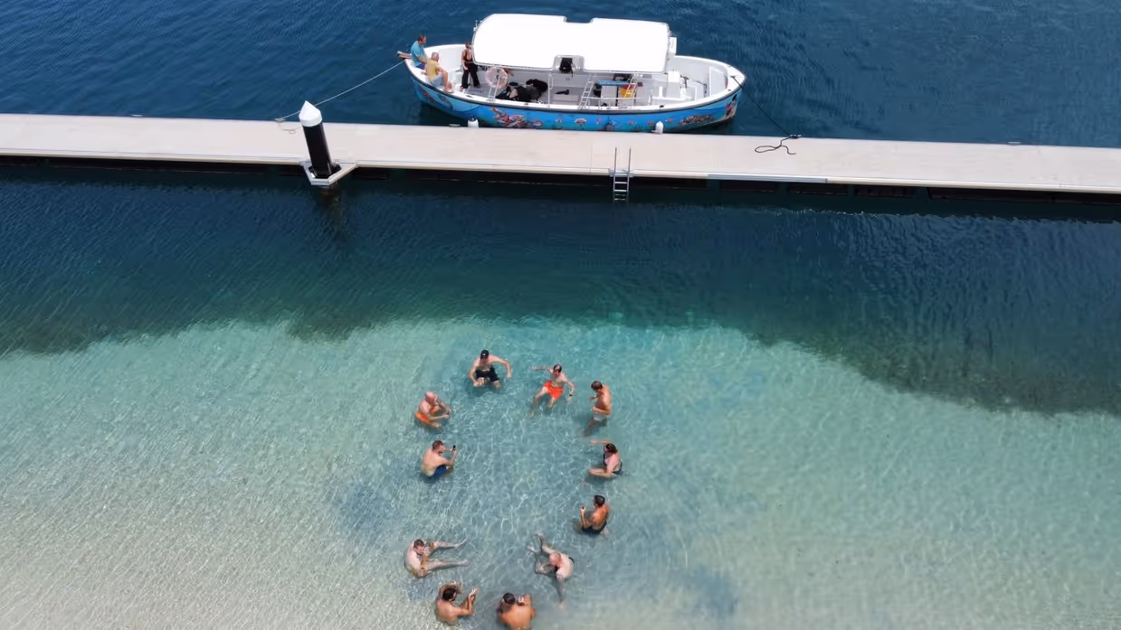 Marechaussees dobberen in een kring in het water op Curaçao. 