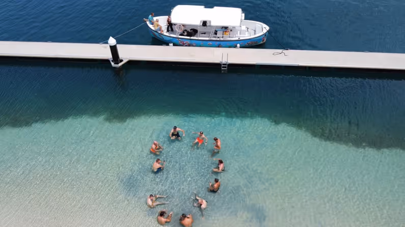 Marechaussees dobberen in een kring in het water op Curaçao. 