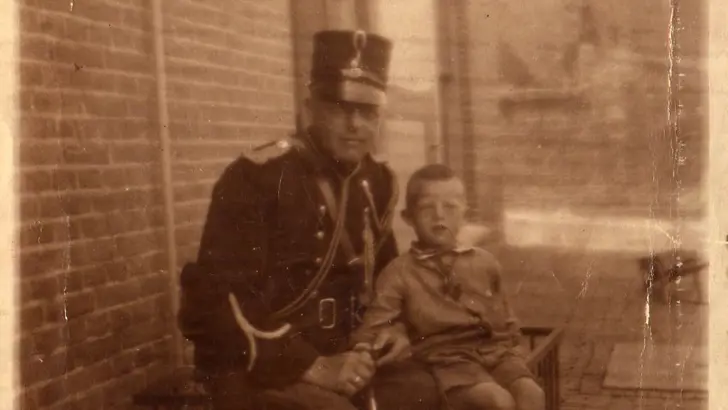 Opa Meulenberg in uniform marechaussee met kind op de foto.