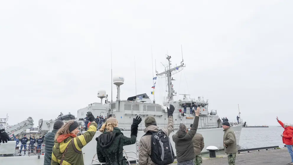 Op de kade zwaaien de thuisblijvers naar de bemanning op het schip.