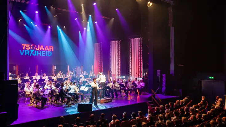 Marinierskapel op podium, met tekst op achtergrond: 75 jaar Vrijheid.
