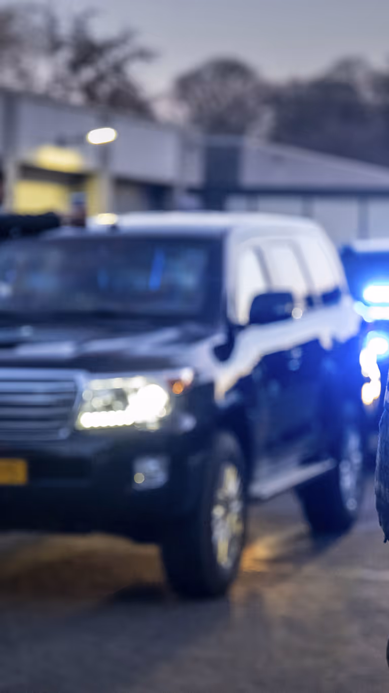 Voertuigen van de ME en politie met mannen met schilden ervoor.