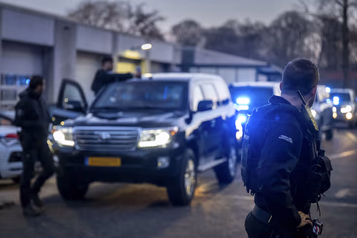 Voertuigen van de ME en politie met mannen met schilden ervoor.
