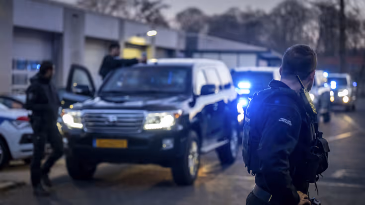 Voertuigen van de ME en politie met mannen met schilden ervoor.