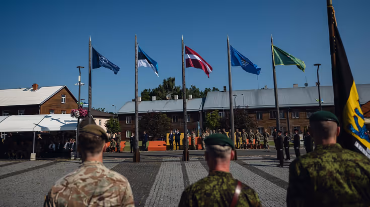 Militairen en vlaggen op een paradeplaats tijdens een overdracht.