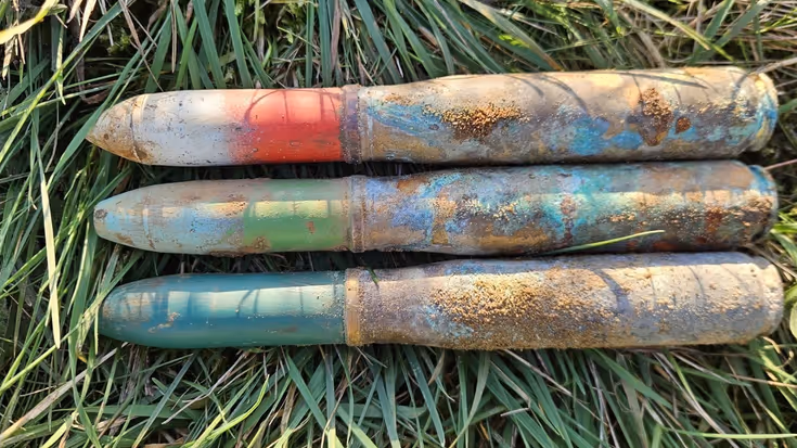 3 granaten naast elkaar in het gras.