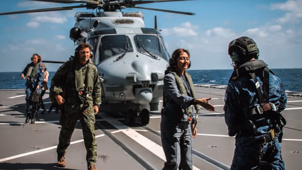 De minister steekt haar hand uit naar een militair.