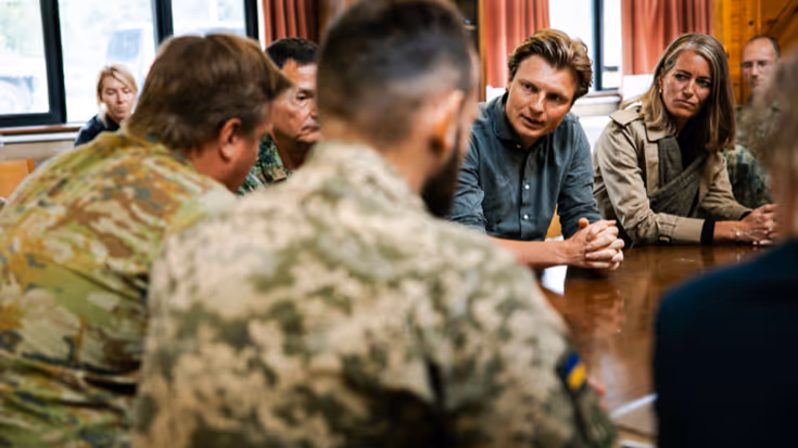 Minister Brekelmans aan tafel in overleg met militairen.