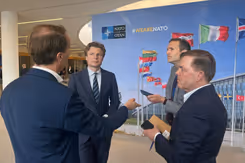 De minister in gesprek met journalisten.