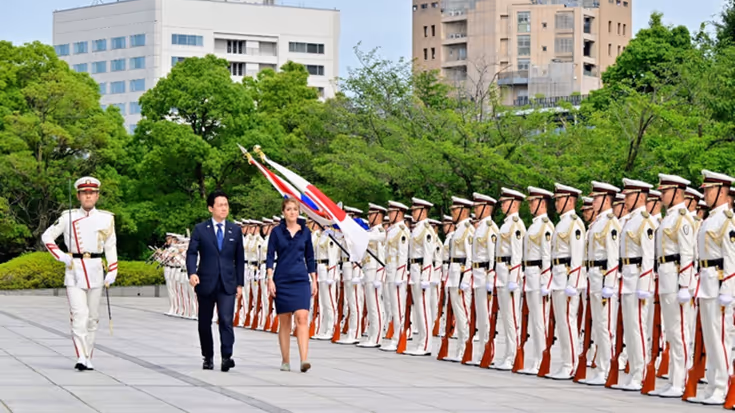 De ministers lopen langs Japanse militairen. 