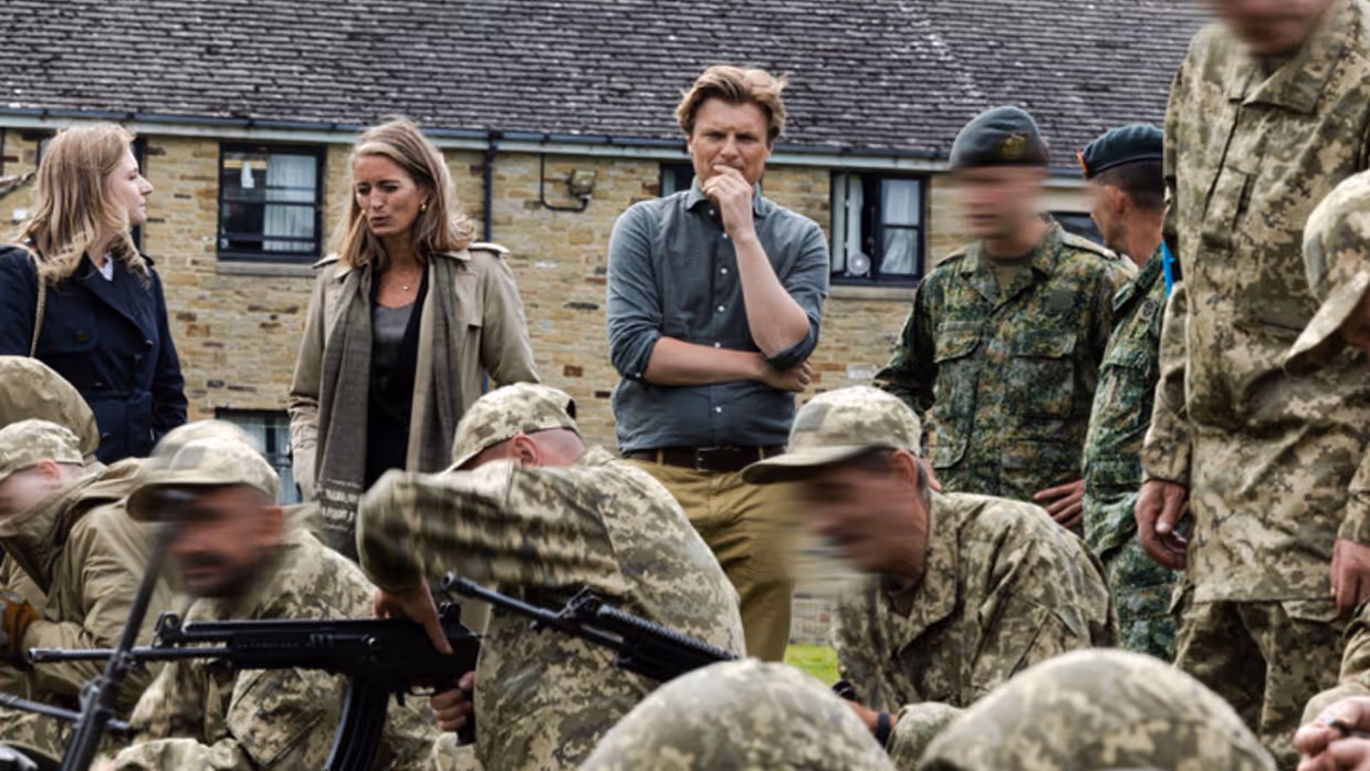 Minister Brekelmans kijkt toe hoe militairen trainen met wapens.