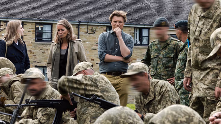 Minister Brekelmans kijkt toe hoe militairen trainen met wapens.