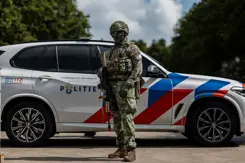 Militair poseert voor een politieauto.
