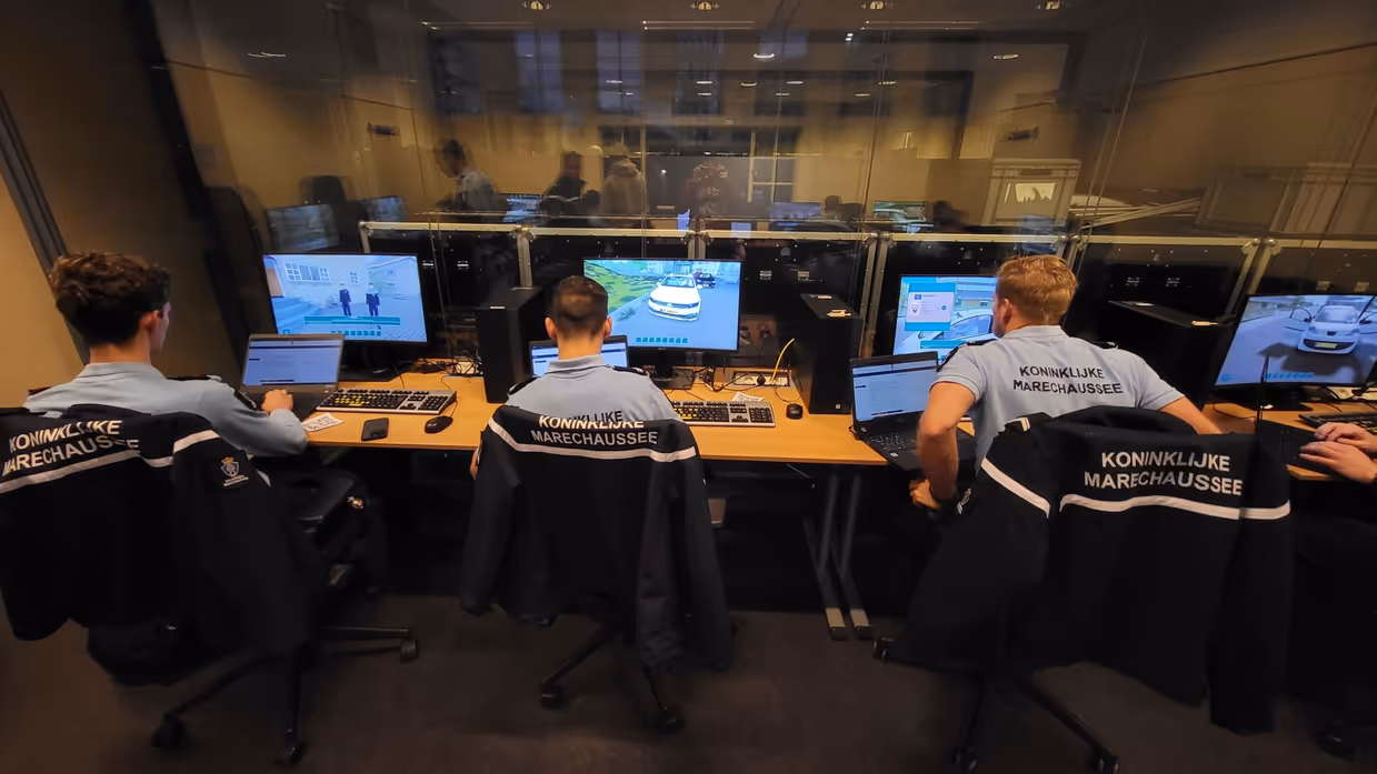 Drie marechaussees in opleiding zitten achter de PC om te trainen met de IBT-game.