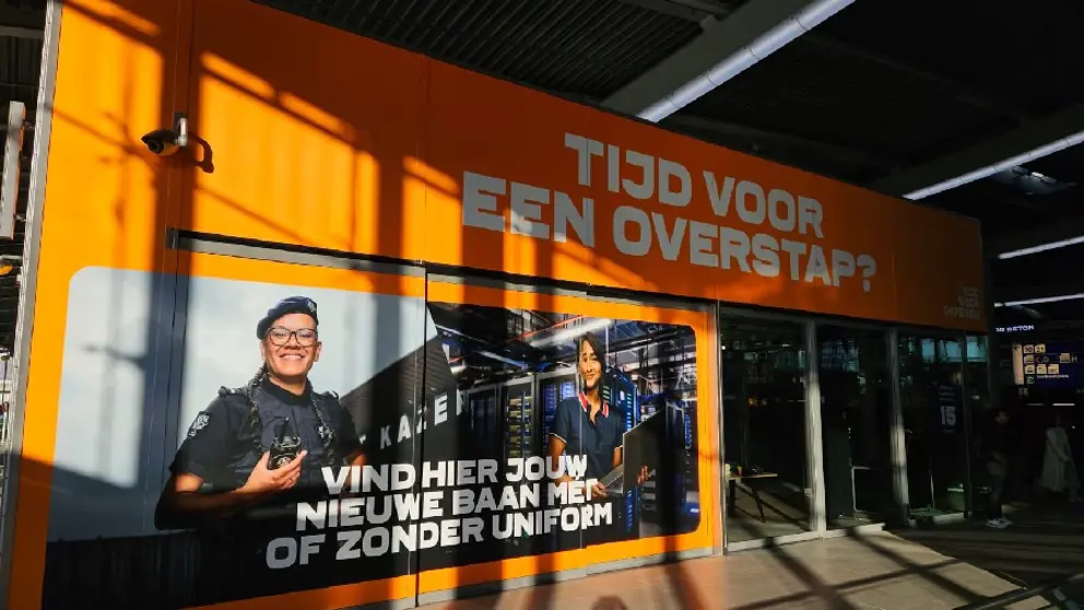 Grote oranje zuil en afbeelding van militairen. Tekst luidt: Tijd voor een overstap. Vind hier jouw baan met of zonder uniform.